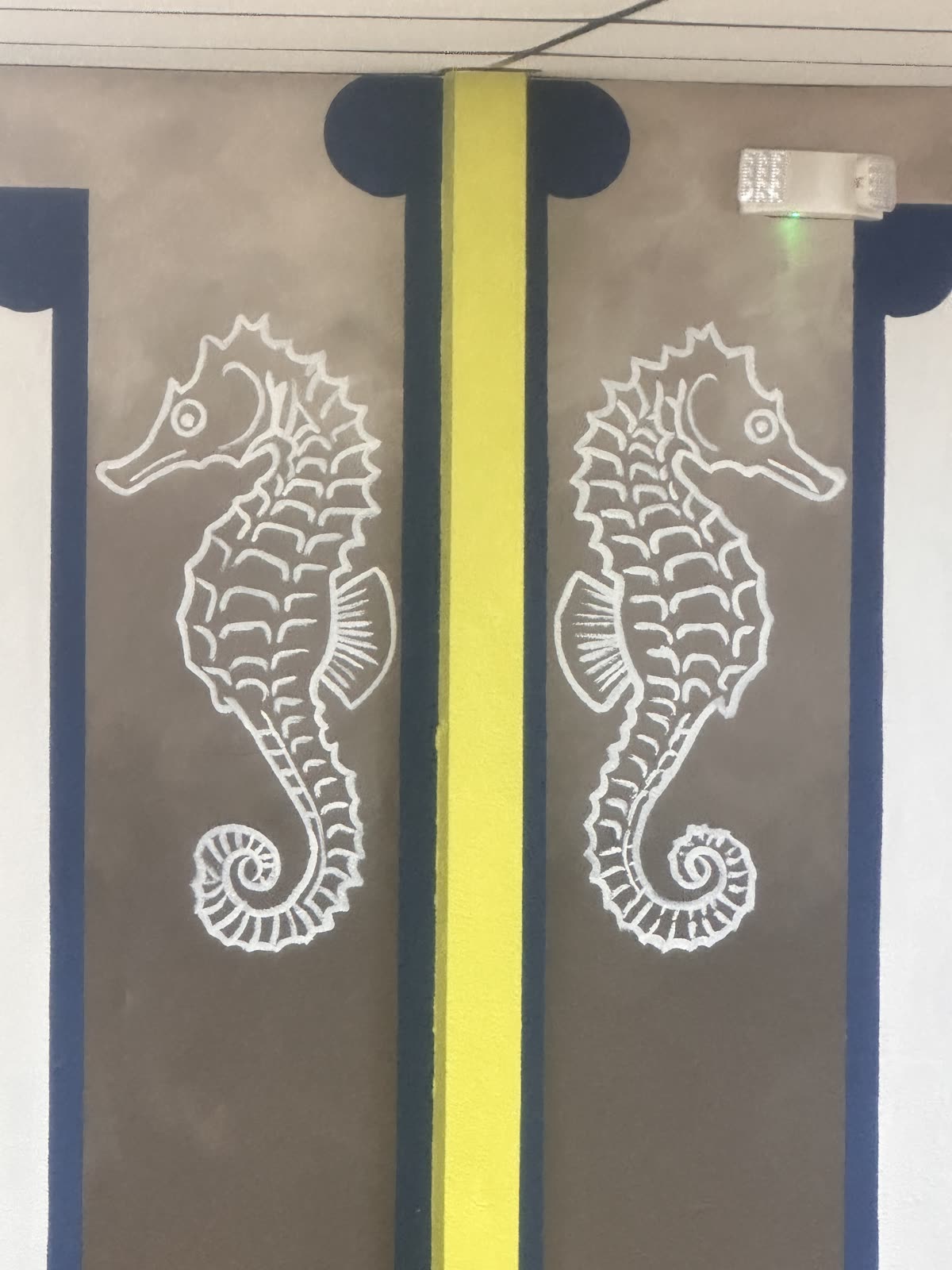 Twin seahorse murals flanking a lime-green column